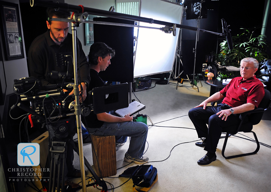 Jeff Tanner, left, of Eyevox Film & Video Production, gets the camera ready as Eric Hughes, creative director for MadGenius Inc., prepares to interview Gibbs in his office  