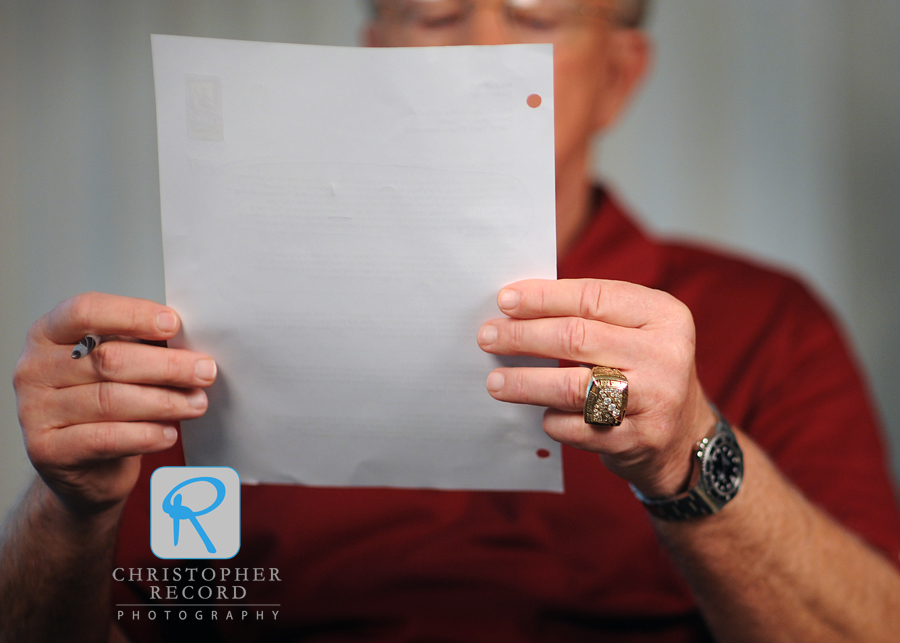 Gibbs, sporting one of his three Super Bowl rings, studies a script for a radio spot