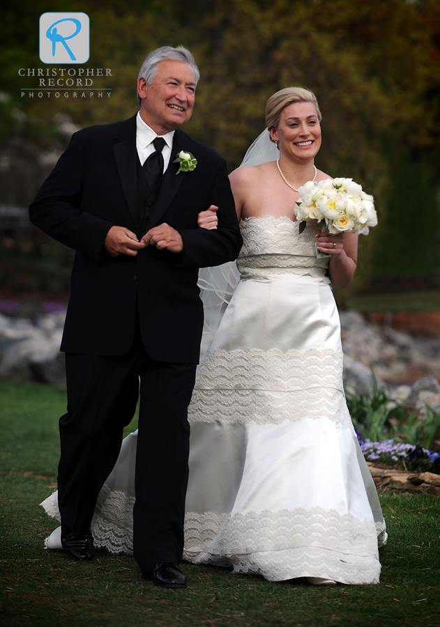 Alison's father walks her to the ceremony