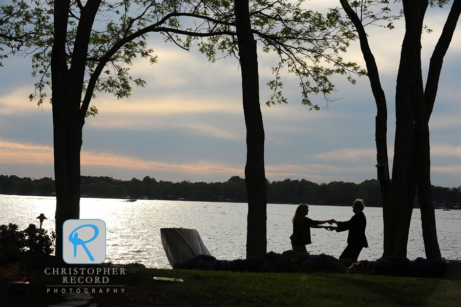 A couple begins an impromptu dance along the water's edge