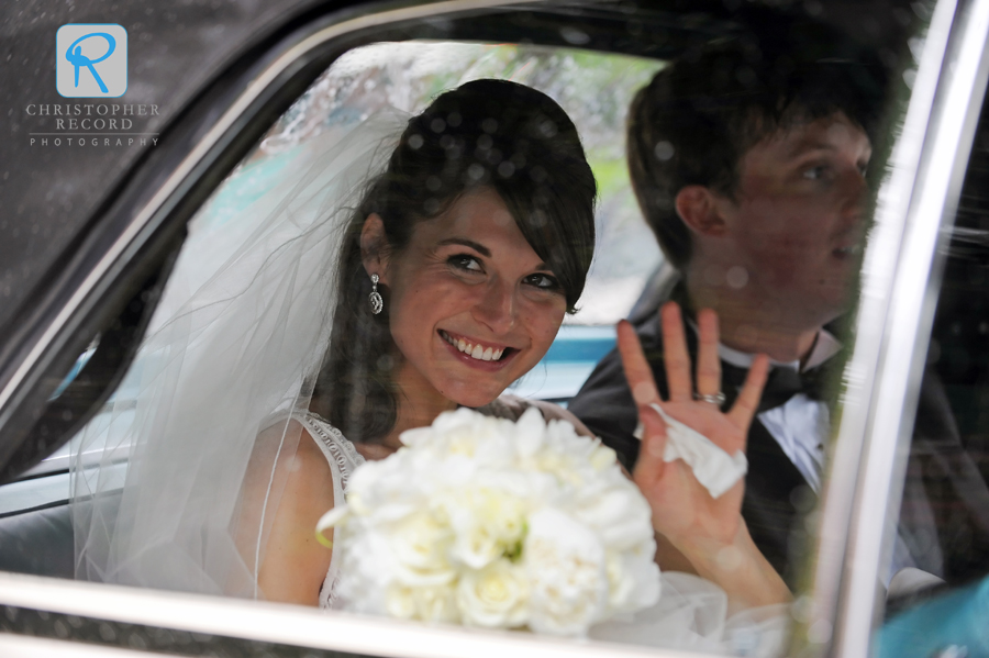 Kelsey gives a wave as they head out in a vintage Lincoln Continental