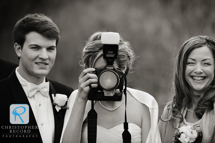 Liz turns the tables on the photographers as Michael and her mother look on