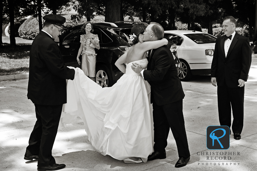 Amy's mother and father look on as she is greeted by John's father