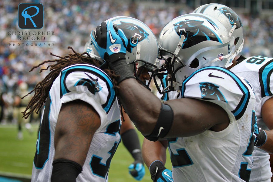 Charles Godfrey, left, and John Beason celebrate Godfrey's interception for a touchdown