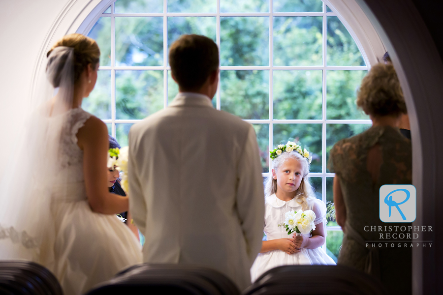 Flower girl Sarah glances the bride and groom